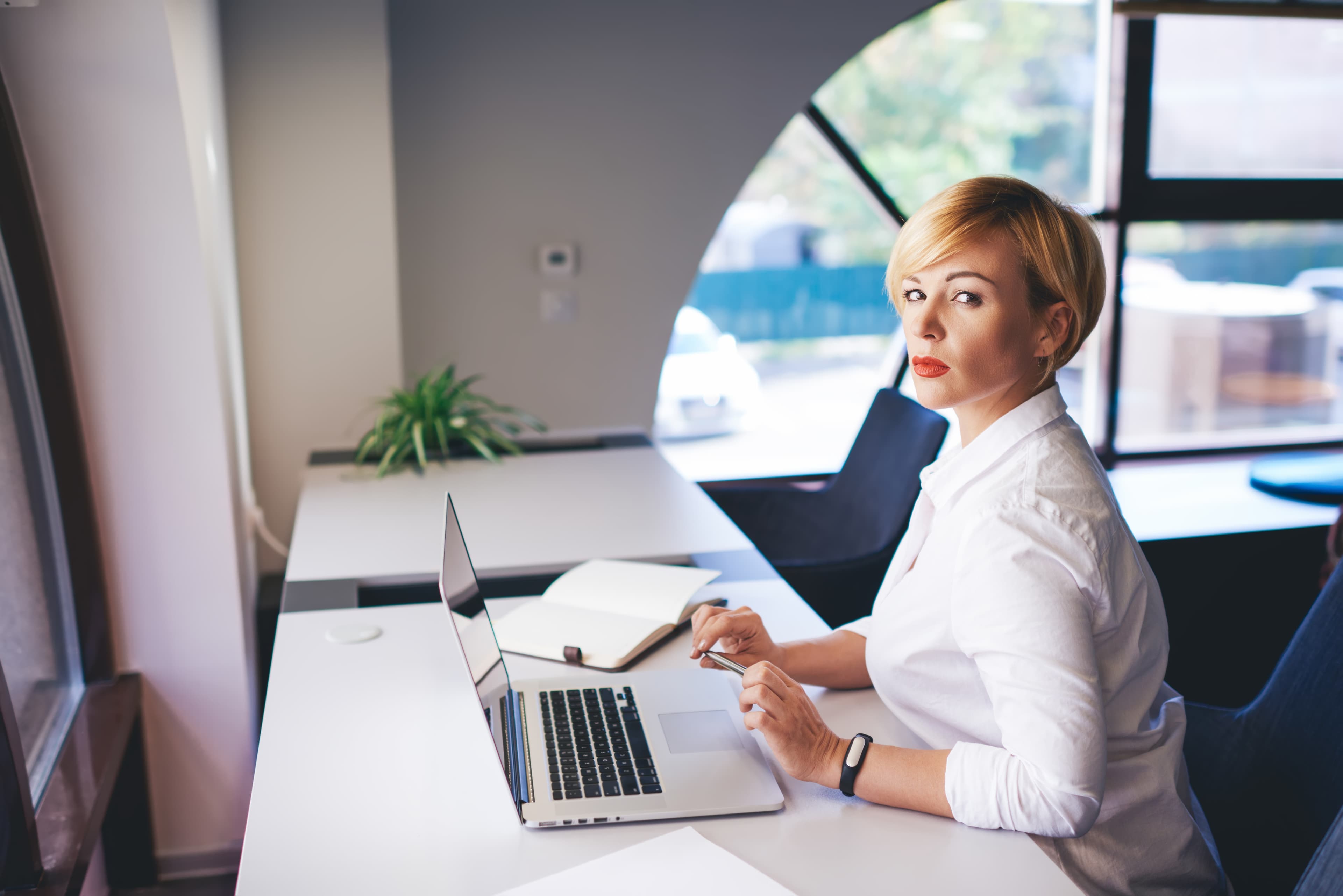Professional manager analysing compliance data on laptop in modern office