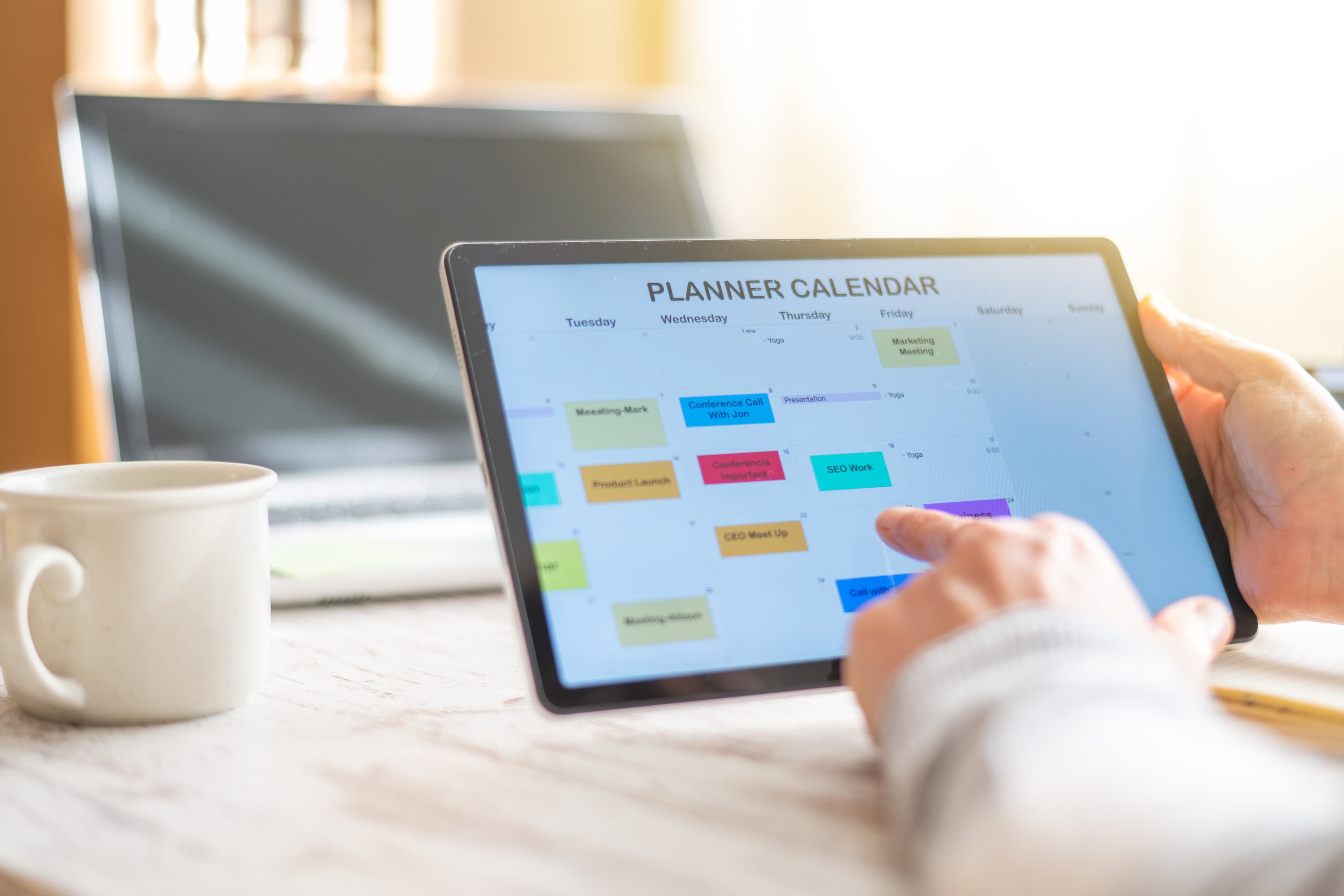 Person planning weekly schedule on digital tablet planner calendar