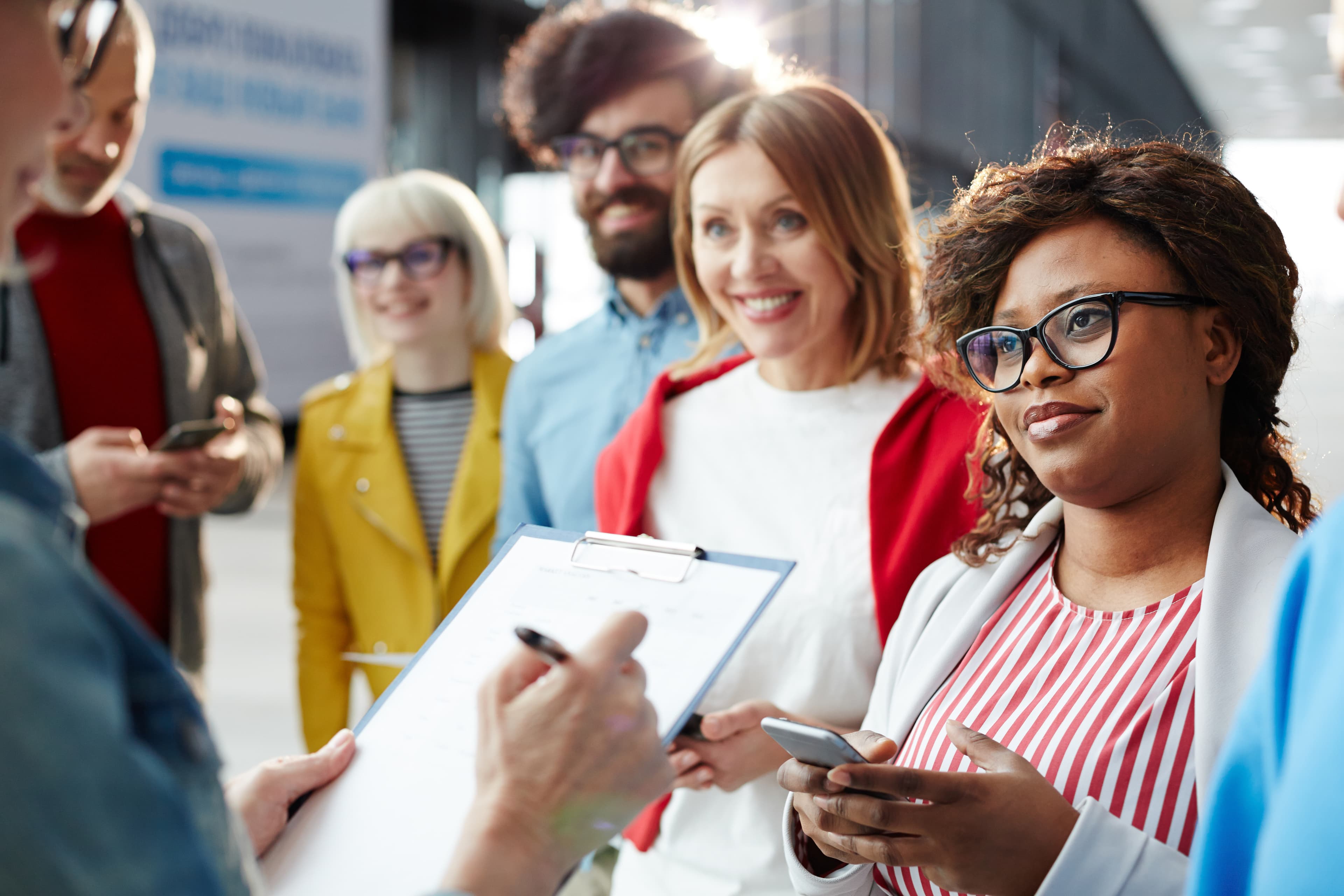 Diverse team checking attendance and verifying worker credentials on clipboard
