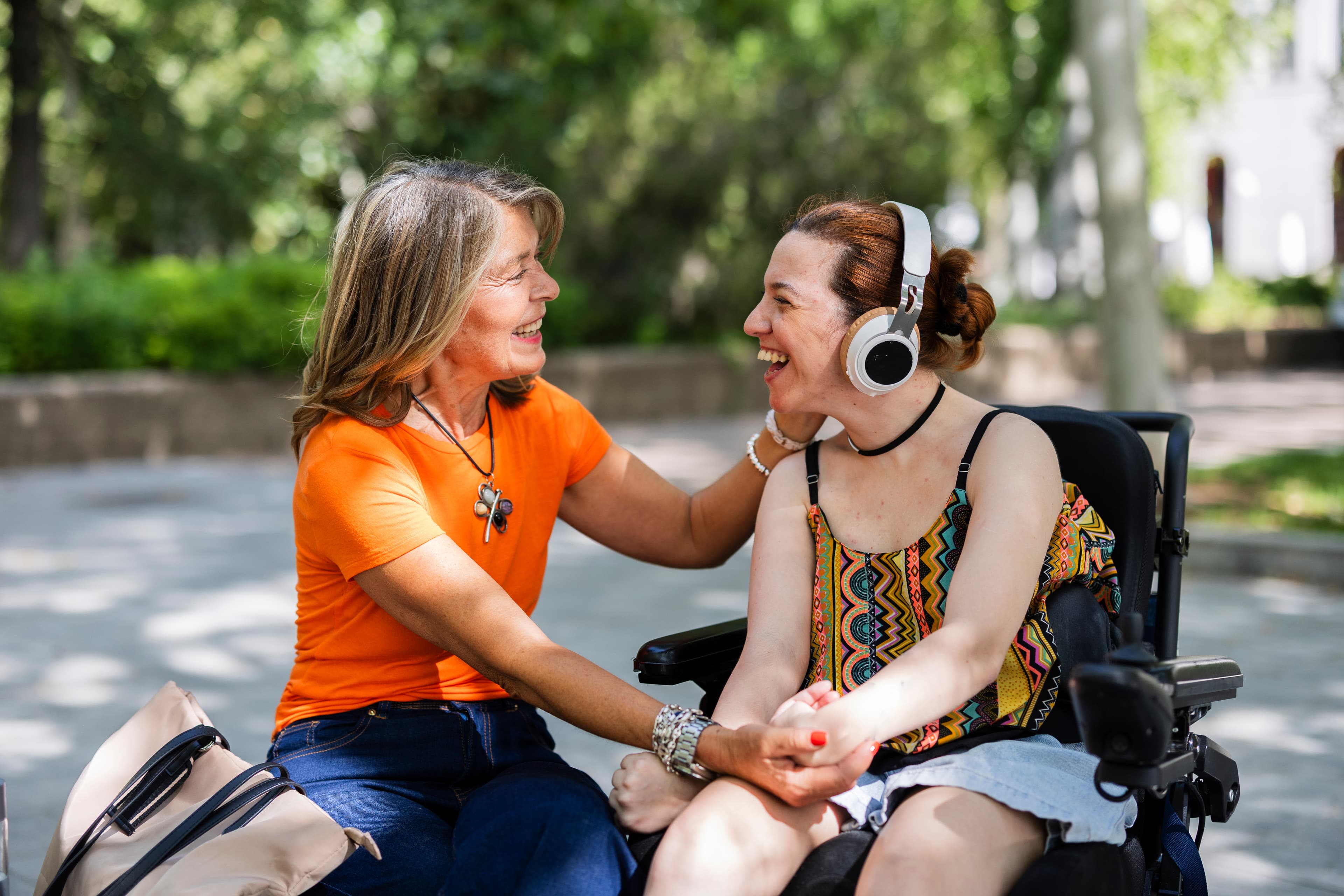 Support worker sharing a joyful moment with disability participant outdoors