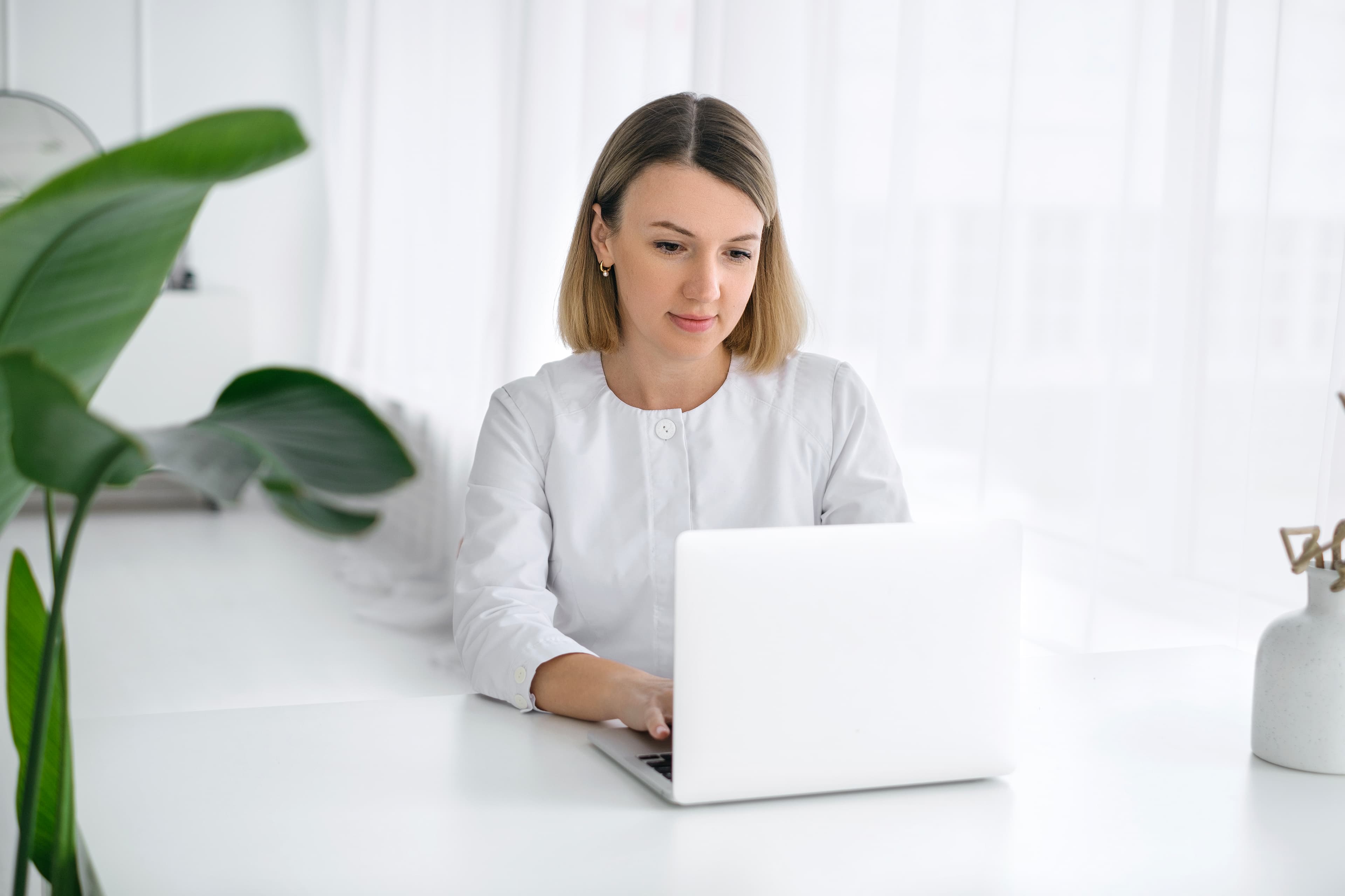 Professional setting up account on laptop in bright modern office